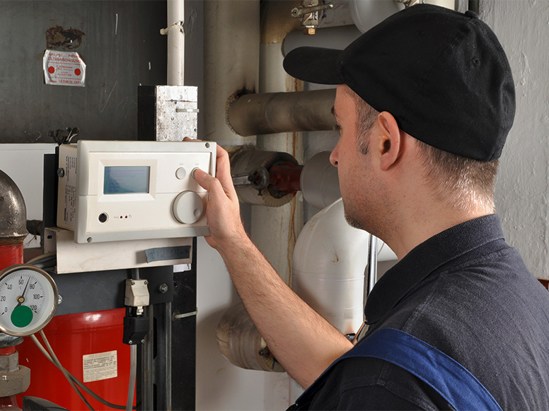 Heizungsbauer kontrolliert eine moderne Heizungsanlage im Heizkeller und führt fachgerechte Wartungsarbeiten für zuverlässige Heiztechnik in Aachen durch.