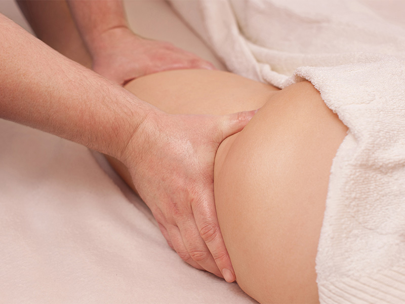 Physiotherapeut führt Anti-Cellulite-Massage an Oberschenkel und Gesäß durch – Lymphdrainage in Aachen zur Förderung der Blutzirkulation.
