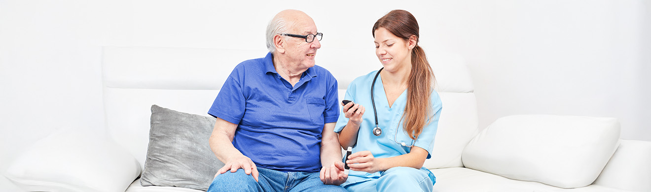 Pflegekraft misst bei einem älteren Patienten den Blutzucker und unterstützt die professionelle medizinische Versorgung im häuslichen Umfeld.