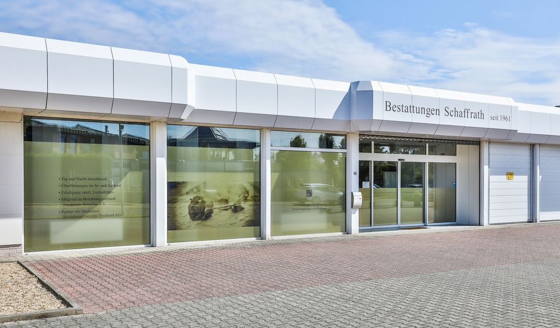 Außenansicht des Bestattungsinstituts Bestattungen Schaffrath in Geilenkirchen mit Eingangsbereich und Firmenbeschilderung.